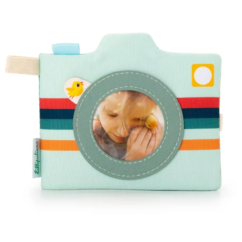 The Lilliputiens I'm Discovering Joe Photo Album is a charming light blue fabric camera toy, ideal for car journeys. It features colorful stripes, a circular window with a small yellow toy bird inside, and includes a fabric tag and bird graphic near the lens—a perfect gift for parents.
