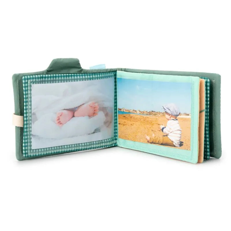 The Lilliputiens I'm Discovering Joe Photo Album, featuring a small, open design with a green cover, displays on its left page baby feet wrapped in a white blanket and on the right an image of a hat-wearing baby on a sandy beach—a perfect gift for parents cherishing these moments.