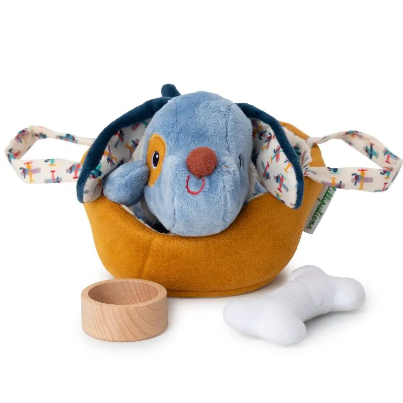 The Lilliputiens I'm Exploring Jules Dog with Basket features a cute blue and brown puppy plush toy in a yellow fabric basket with colorful handles. A wooden ring and plush white bone sit in front, ready for playtime adventures.