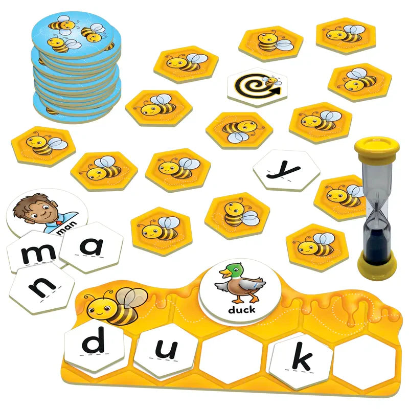 The Orchard Toys Buzz Words is a children's board game that uses hexagonal tiles featuring bees, letters, and images such as a man and a duck. It comes with an hourglass timer and multiple tile piles, with the word "duck" spelled out on the board.