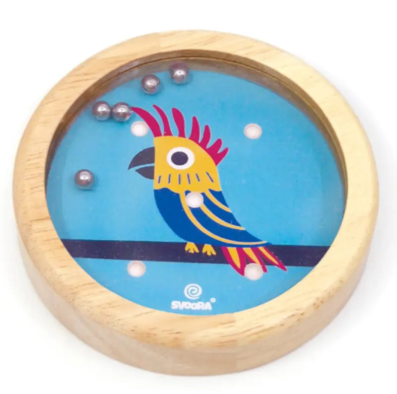 The Wooden Balance Game Parrot is a round handheld wooden maze featuring a colorful parrot on a blue background. Tilt small metal balls into holes around the bird—an ideal travel toy.