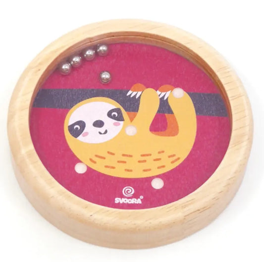 The Wooden Balance Game Sloth is a round wooden toy with a cartoon sloth on a red background. Roll small metal balls into holes for fun—perfect as a travel game for kids.