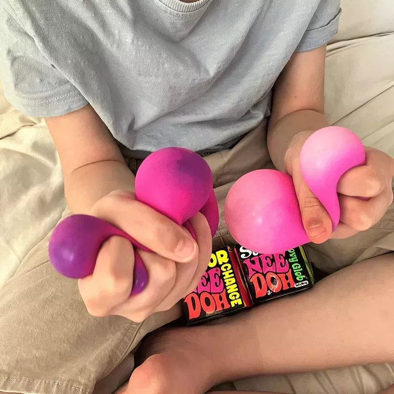 A person holding colorful Mood Change NeeDoh stress balls of different sizes in their hands.