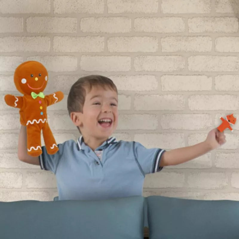 A young boy is holding a Fiesta Crafts Gingerbread Man with Finger Puppets Set.