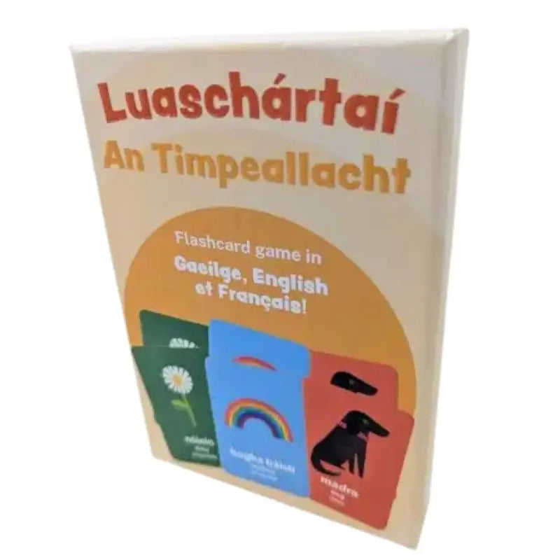 Box of "Luaschártaí - An Timpeallacht," a trilingual (Irish, English, French) flashcard game for language learning. The cream and orange box displays sample cards—daisy, rainbow, and dog.