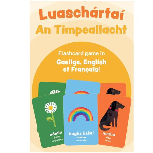 The "Luaschártaí - An Timpeallacht" game box includes trilingual flashcards (Irish, English, French) with images like a daisy, rainbow, and dog—ideal for fun language learning in all three languages.