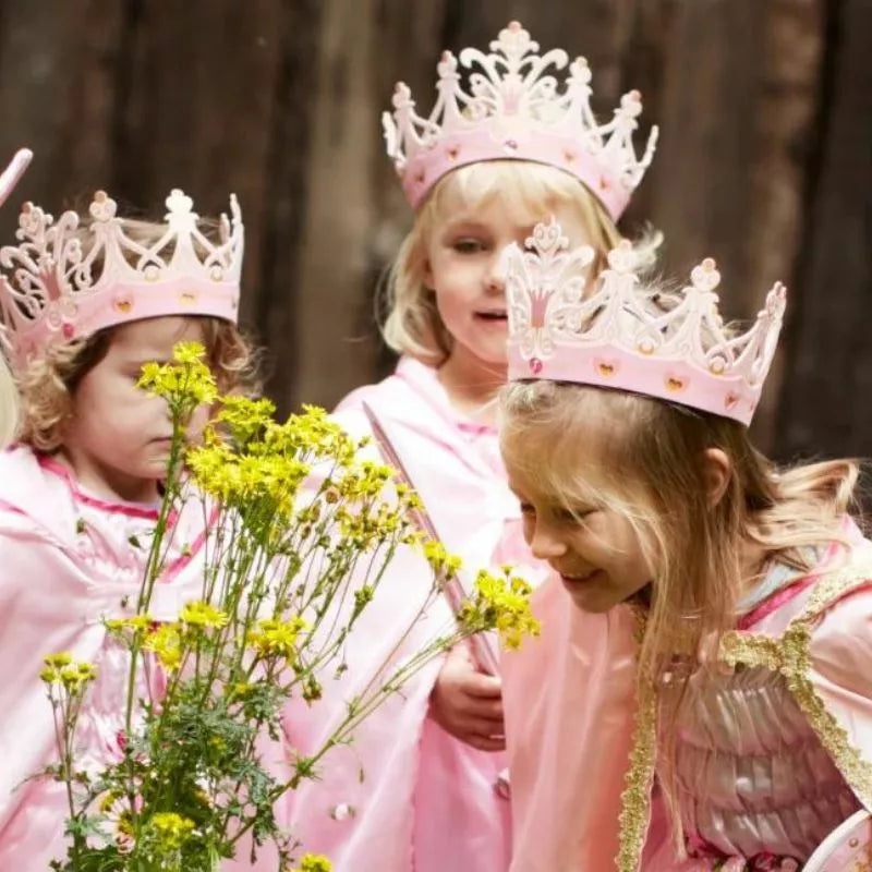 A group of kids performing a puppet show wearing Liontouch Queen Rosa Crowns and flowers.