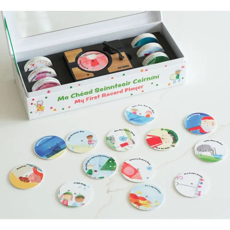 The Mini Gramophone Box Set includes a mini record player and colorful circular discs with illustrations and text, featuring several discs inspired by traditional Irish songs laid out in front of the box.