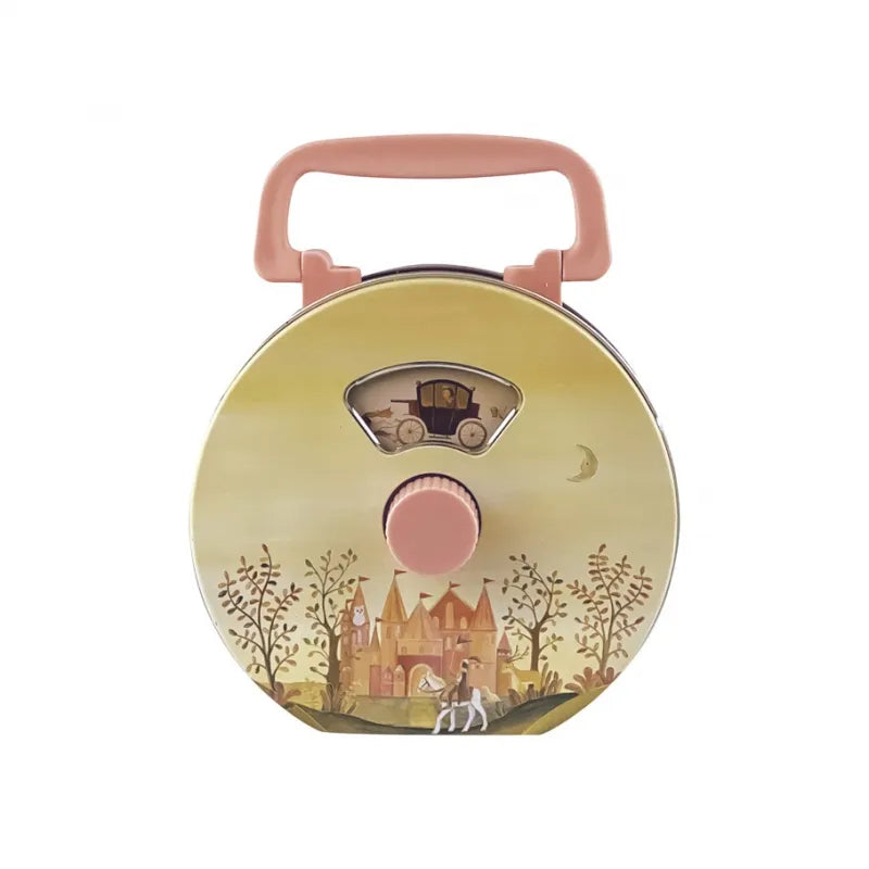 The Musical Radio Princess is a round, pastel yellow children’s lunchbox with a pink handle, decorated with a fairytale castle, trees, horse, and carriage—recalling the charm of classic tin toys.