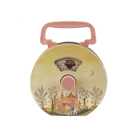 The Musical Radio Princess is a round, pastel yellow children’s lunchbox with a pink handle, decorated with a fairytale castle, trees, horse, and carriage—recalling the charm of classic tin toys.