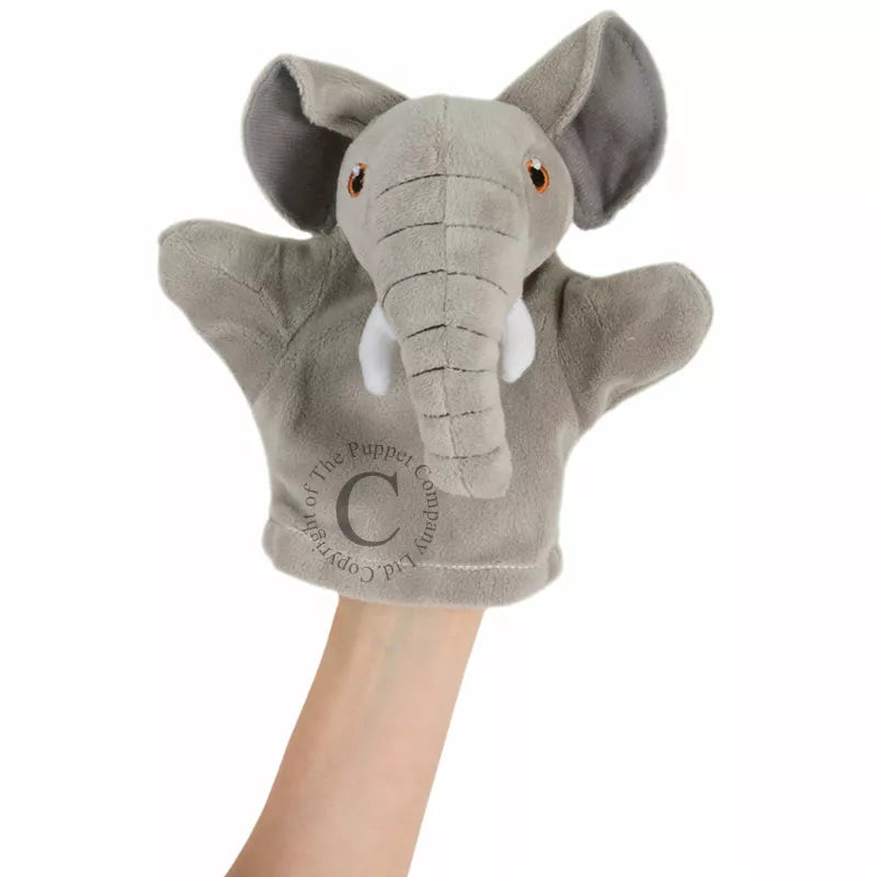 A child's hand holding The Puppet Company My First Puppet Elephant for a puppet show performance.