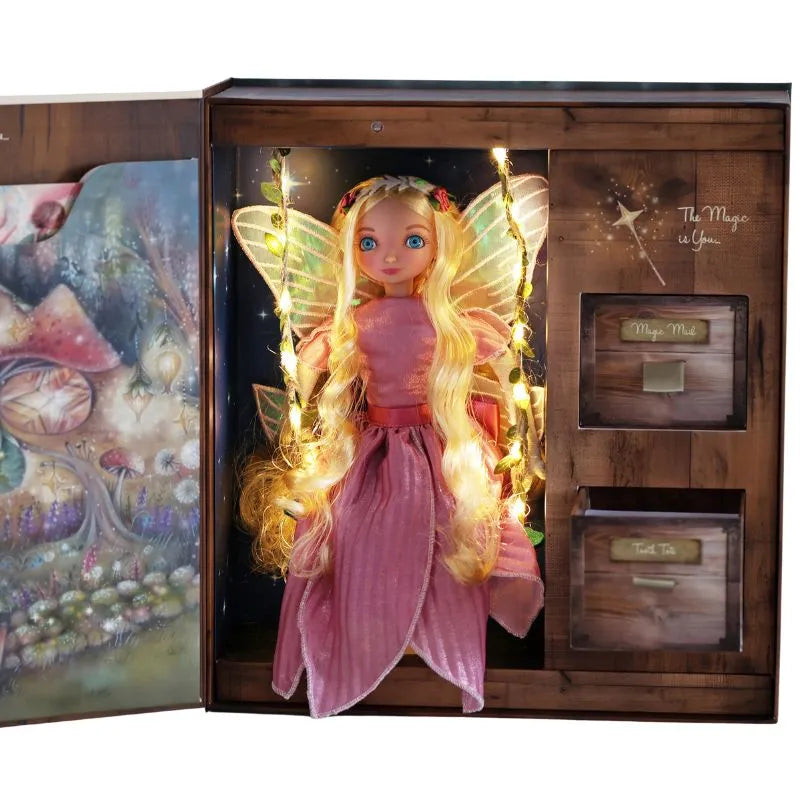 The My Forever Tooth Fairy Gift Set features a blonde Tooth Fairy Doll with long hair, a pink dress, and glowing wings, displayed in an open box with a magical forest design and compartments for "Magic Mist" and "Ticket Talis.