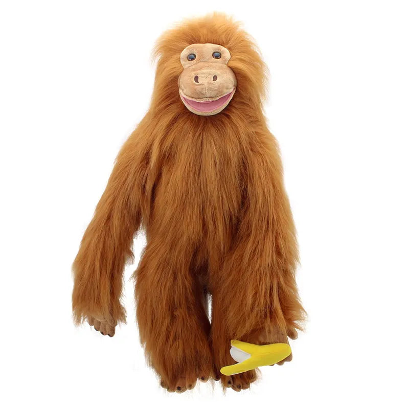 The Puppet Company Large Puppet Orangutan is a plush puppet with vibrant orange fur, standing upright while holding a small yellow banana toy in its right hand. This large hand puppet boasts a smiling face, big round eyes, and has the ability to move its mouth for extra fun during playtime.