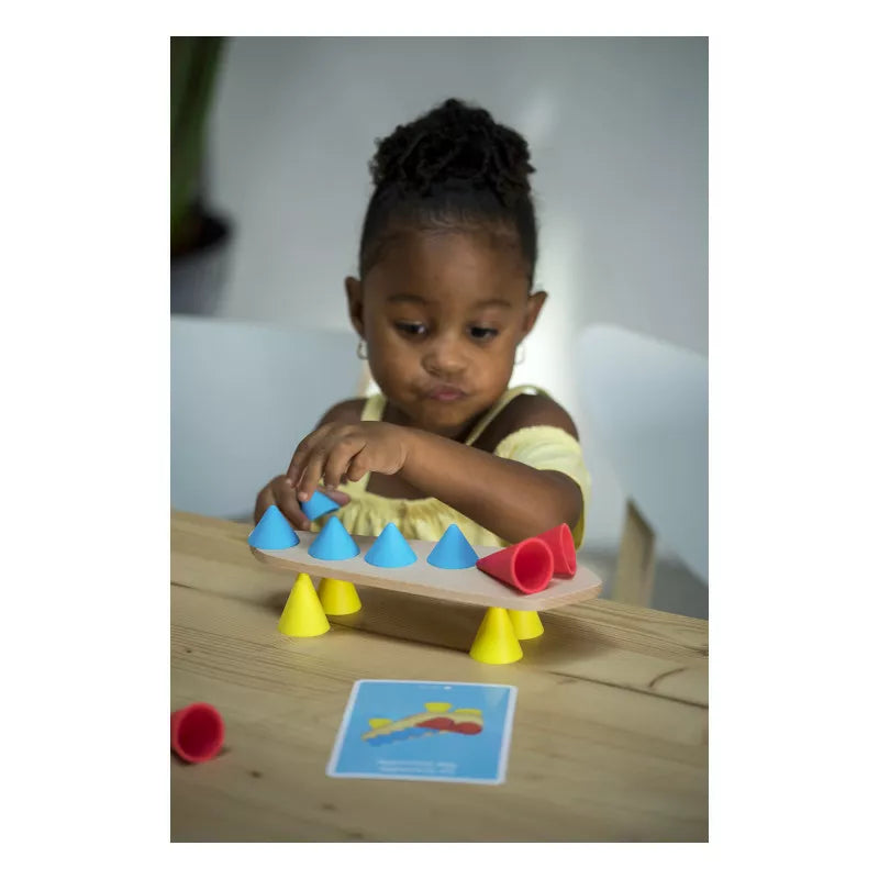 A little girl playing with Piks Construction Creative Cards.