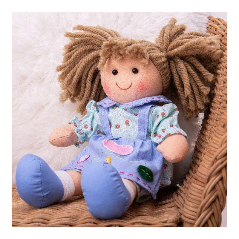 A Bigjigs Grace Doll Small with blonde hair sitting in a wicker basket.