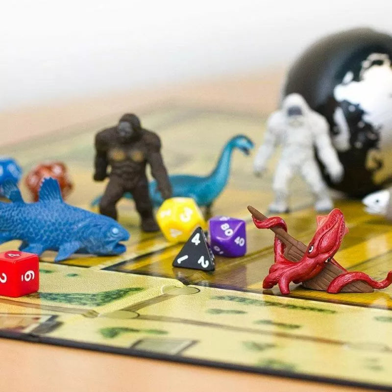 A board game with dice and TOOBS® Figurines Cryptozoology on a table.