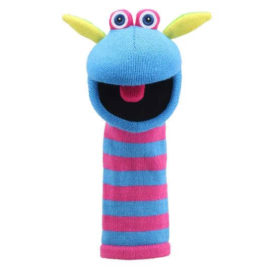 The Puppet Company Sockette Puppet Scorch is shown, featuring a colorful design with blue and pink stripes, a blue face, large googly eyes, and yellow ears. This hand puppet has a wide-open black mouth with a pink tongue sticking out, giving it a cheerful and playful expression.