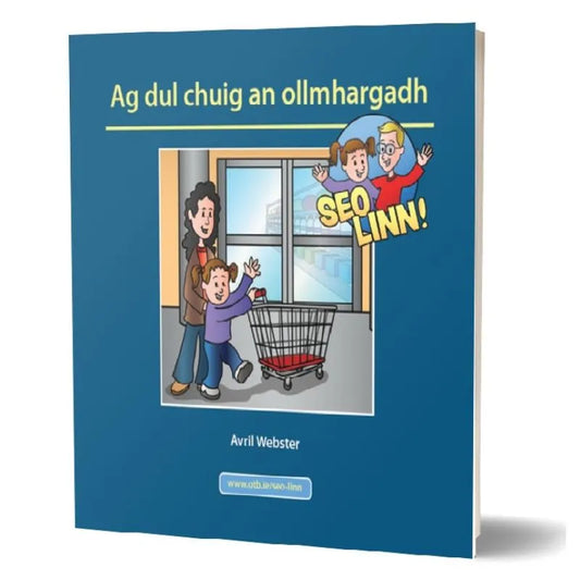 The children’s book titled "Seo linn! – Scéalta Sóisialta Ag dul chuig an ollmhargadh" by Avril Webster features a cover illustration of a smiling adult holding a child's hand in front of a supermarket entrance with a shopping cart. The text above them, perfect for language development, reads "SEO LINN!" in a comic-style speech bubble.
