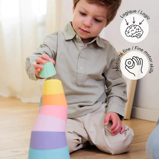 A young boy is having fun with a Stak Baby Toy, developing his fine-motor skills.