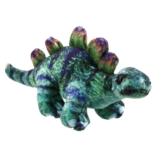 A plush toy resembling a green and blue Stegosaurus dinosaur with a textured, gradient color pattern. The toy, from The Puppet Company, features iconic backplates in a darker hue, a short tail, and four legs, giving it a cute and cuddly appearance. Perfect as a Dinosaur Finger Puppet Stegosaurus for imaginative play!