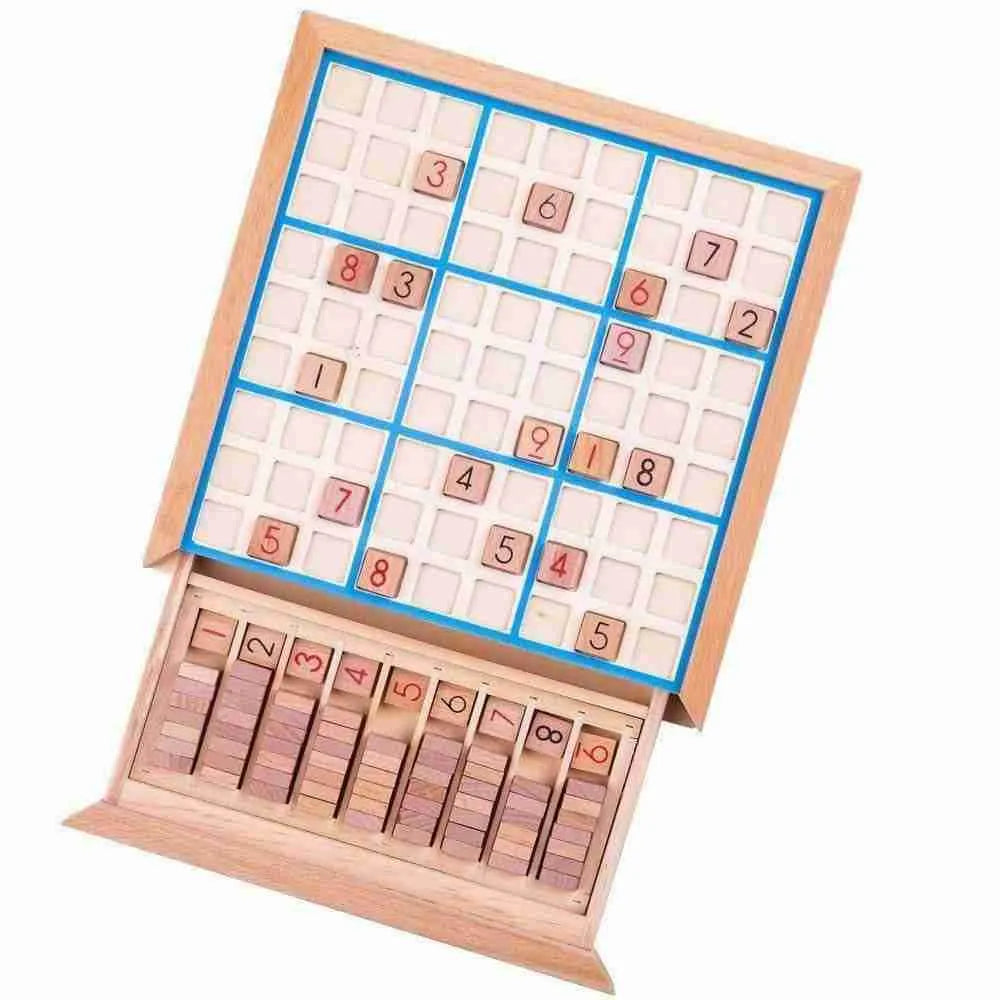 The Bigjigs Sudoku Game is a wooden board game with a partially filled 9x9 grid, ideal for brain training. It includes numbered tiles placed on the board and a compartment underneath that holds extra tiles numbered 1 to 9.