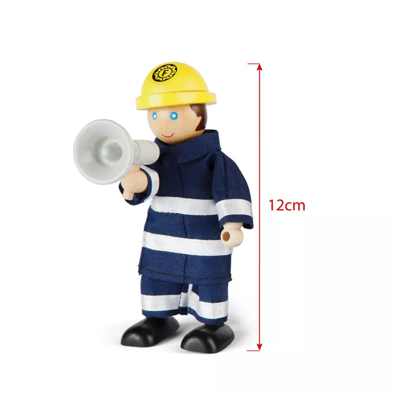 A Firefighters Set toy figure of a firefighter wearing a blue uniform with white stripes and a yellow helmet, holding a megaphone, designed for imaginative play. Next to it is a red measurement line showing the height.