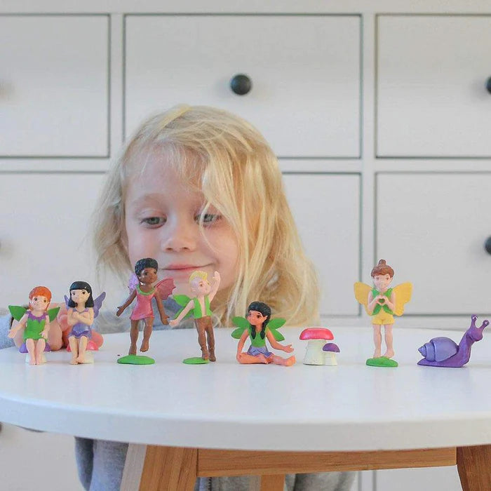 A little girl is putting on a puppet show with a group of TOOBS® figurines.