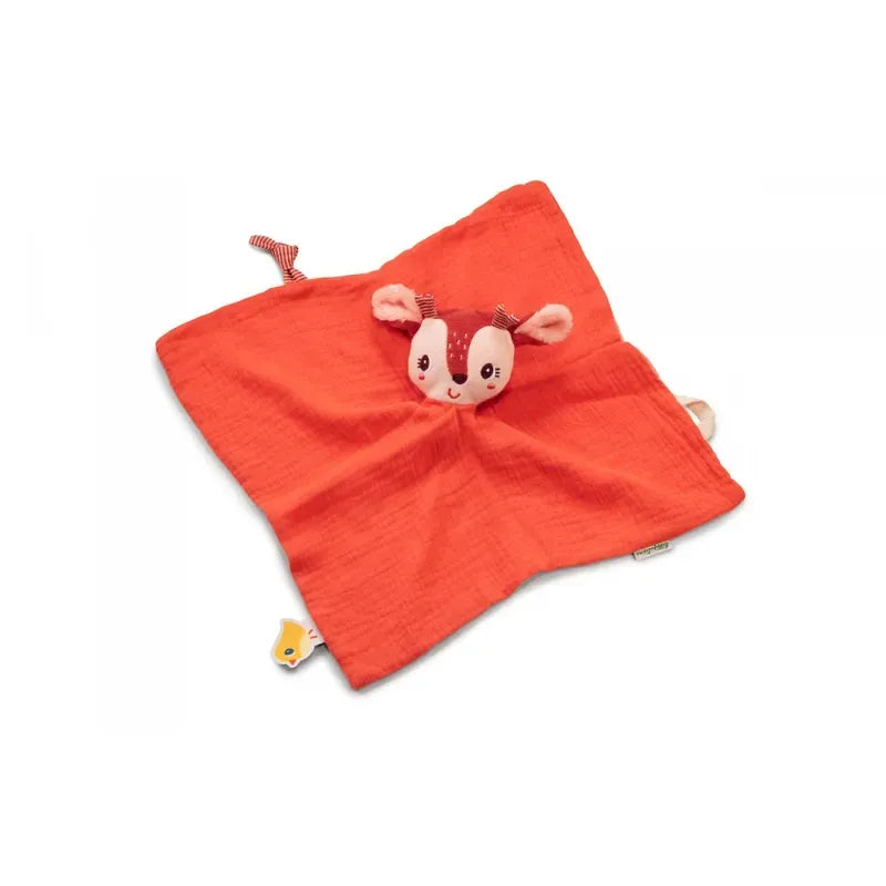 A soft, orange Lilliputiens Stella the Fawn Comforter with a cute deer plush head attached at the center. This organic comforter features small tags, including a yellow one with a chick drawing. The deer has a smiley face, antlers, and large ears, making it an adorable and machine-washable baby toy for infants.