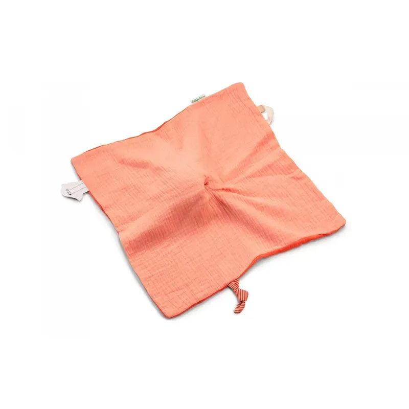 A soft, square-shaped, coral-colored fabric cloth with a textured surface, this Lilliputiens Stella the Fawn Comforter features small tags hanging from two corners and a ribbon loop at the bottom center. The plush material makes it a comforting baby toy while being machine-washable for easy care.