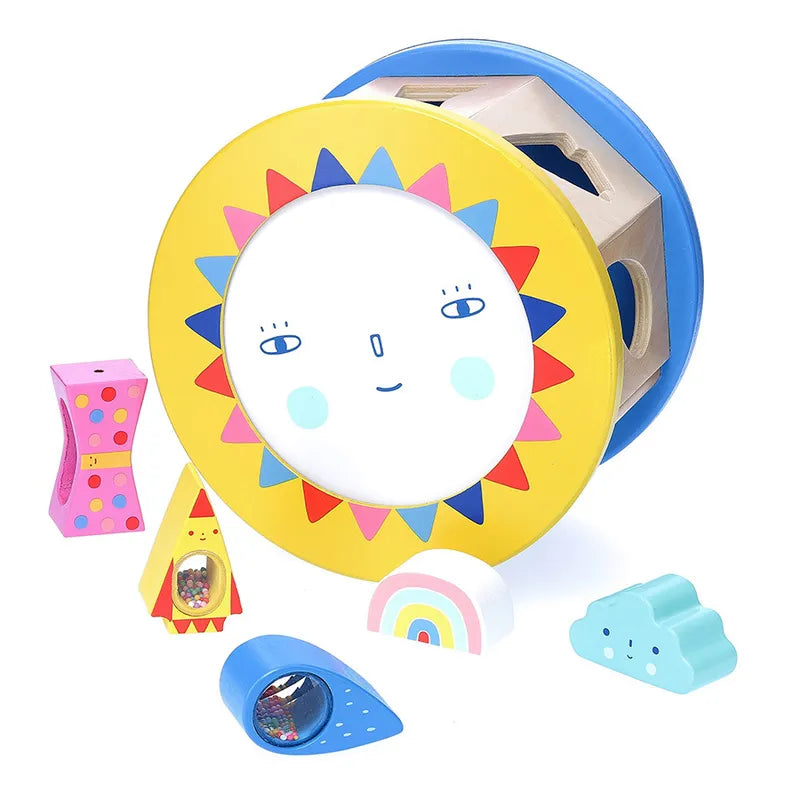 Introducing the Vilac Night and Day Shape Sorter, a vibrant wooden toy featuring a round rolling sorter adorned with a cheerful smiling face design. It includes an array of shapes such as a rainbow, teardrop, cloud, polka-dotted triangle, and more. This engaging toy is perfect for early learning and developing fine motor skills as children match and insert shapes into their corresponding holes.