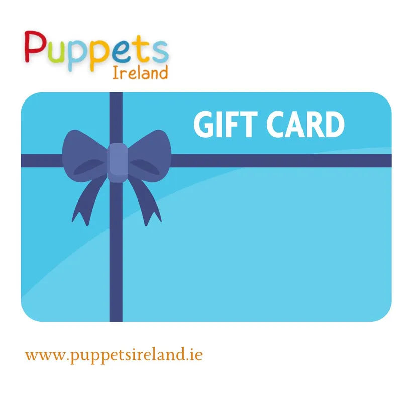 An image of a Puppets Ireland Gift Card with a blue background, featuring a dark blue ribbon and bow. The text "GIFT CARD" is written in white on the top right. The Puppets Ireland logo is at the top, and the website www.puppetsireland.ie is at the bottom—perfect for stress-free online shopping.