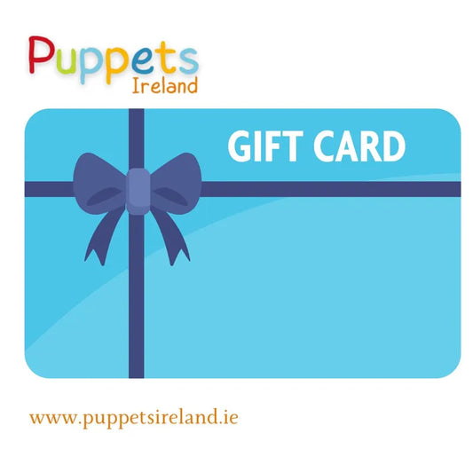 An image of a Puppets Ireland Gift Card with a blue background, featuring a dark blue ribbon and bow. The text "GIFT CARD" is written in white on the top right. The Puppets Ireland logo is at the top, and the website www.puppetsireland.ie is at the bottom—perfect for stress-free online shopping.