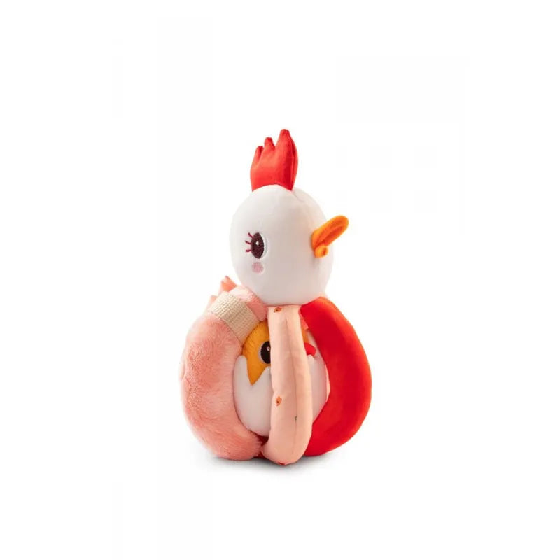 A Lilliputiens Paulette Rattle With Handles depicting a cute chicken with a red comb and orange beak is shown sitting. The machine-washable toy has large eyes with eyelashes and is primarily white with pink and red accents. The chicken, also functioning as a baby rattle, is holding a round orange object embroidered with yellow and pink details.