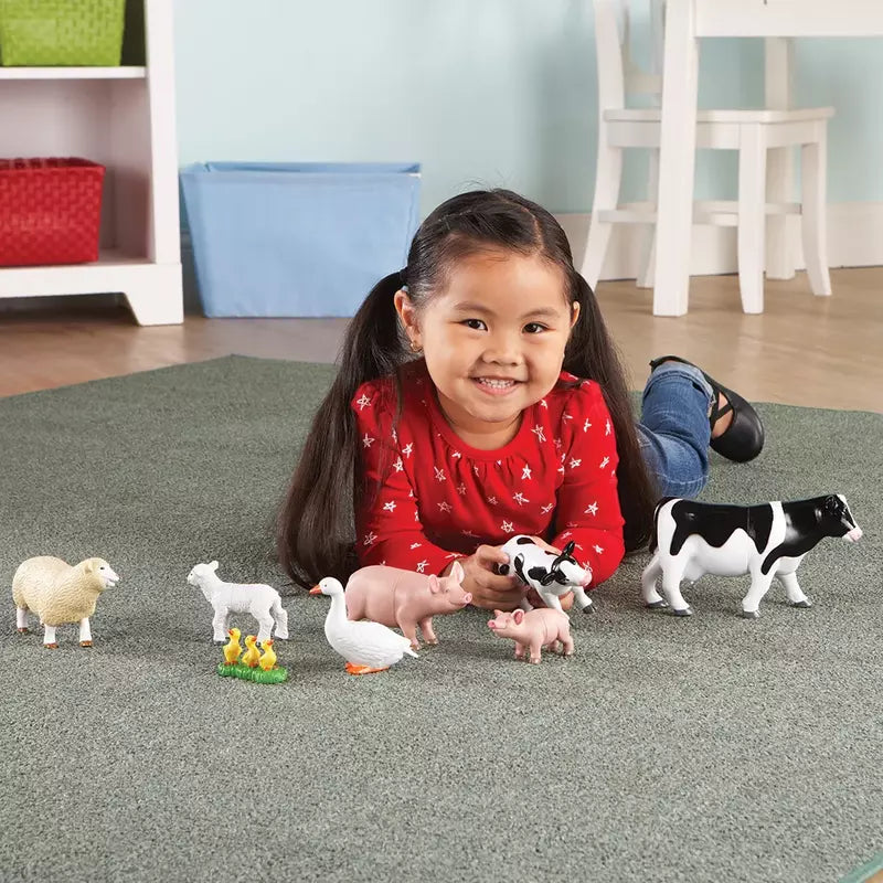 A little girl playing with Learning Resources Jumbo Farm Animals - Mommas and Babies.
